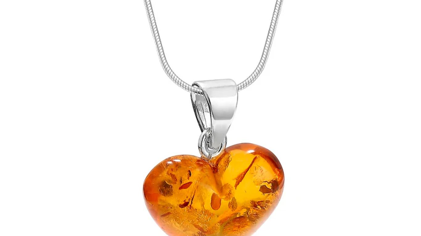 A heart-shaped amber pendant on a silver snake chain necklace.