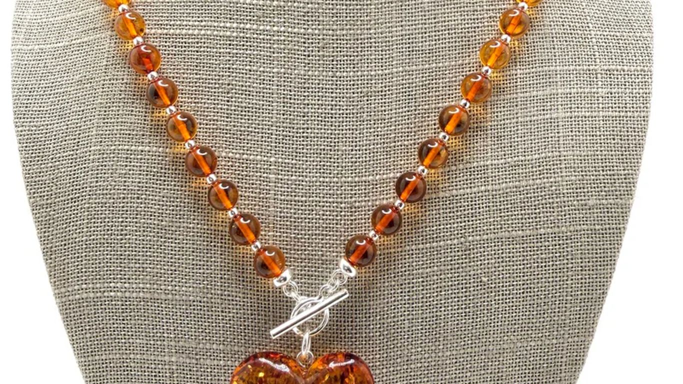Amber beaded necklace with a large, clear amber heart pendant.